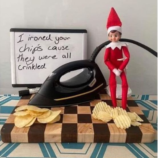Elf with an iron and crisps, and a sign saying 