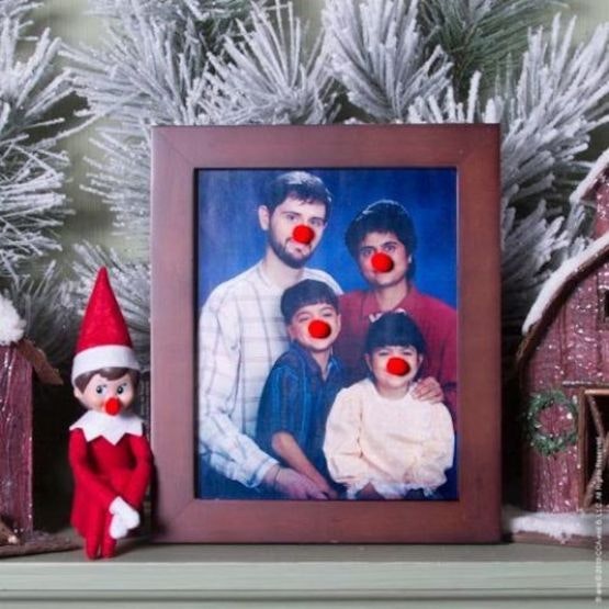 A family photo with red noses stuck onto each face and the Elf on the shelf sitting nearby