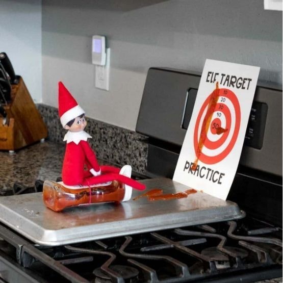 An elf shotting ketchup at a target on the oven