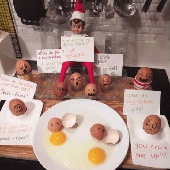 An elf with a selection of jokes written on cards and some whole eggs and some cracked eggs