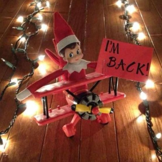 elf on a toy plane with fairy lights either side as a landing strip