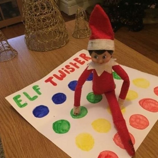 An elf playing twister on a homemade mini twister mat