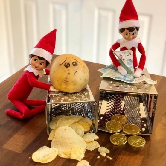 Two elves creating pound coins by grating a £5 note and crisps by grating a photo