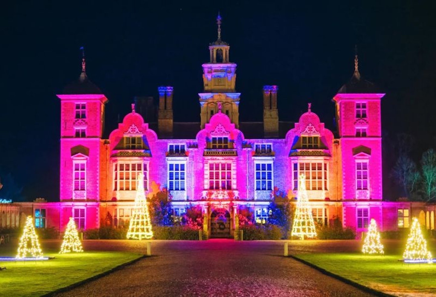 A historic National Trust site lit up with colourful lights for Christmas