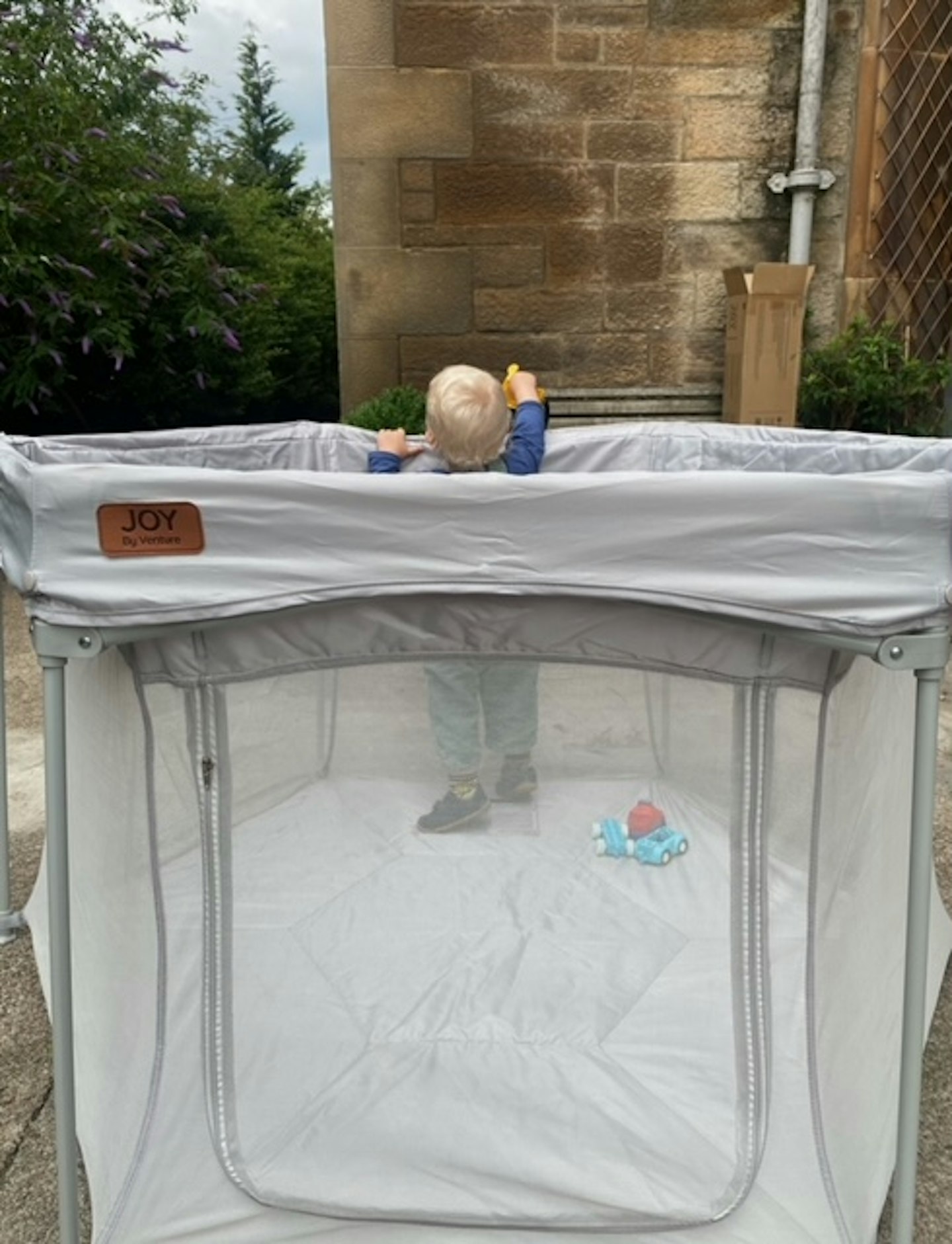 VENTURE-All-Stars-JOY-Playpen  being used outdoors with a baby standing up inside