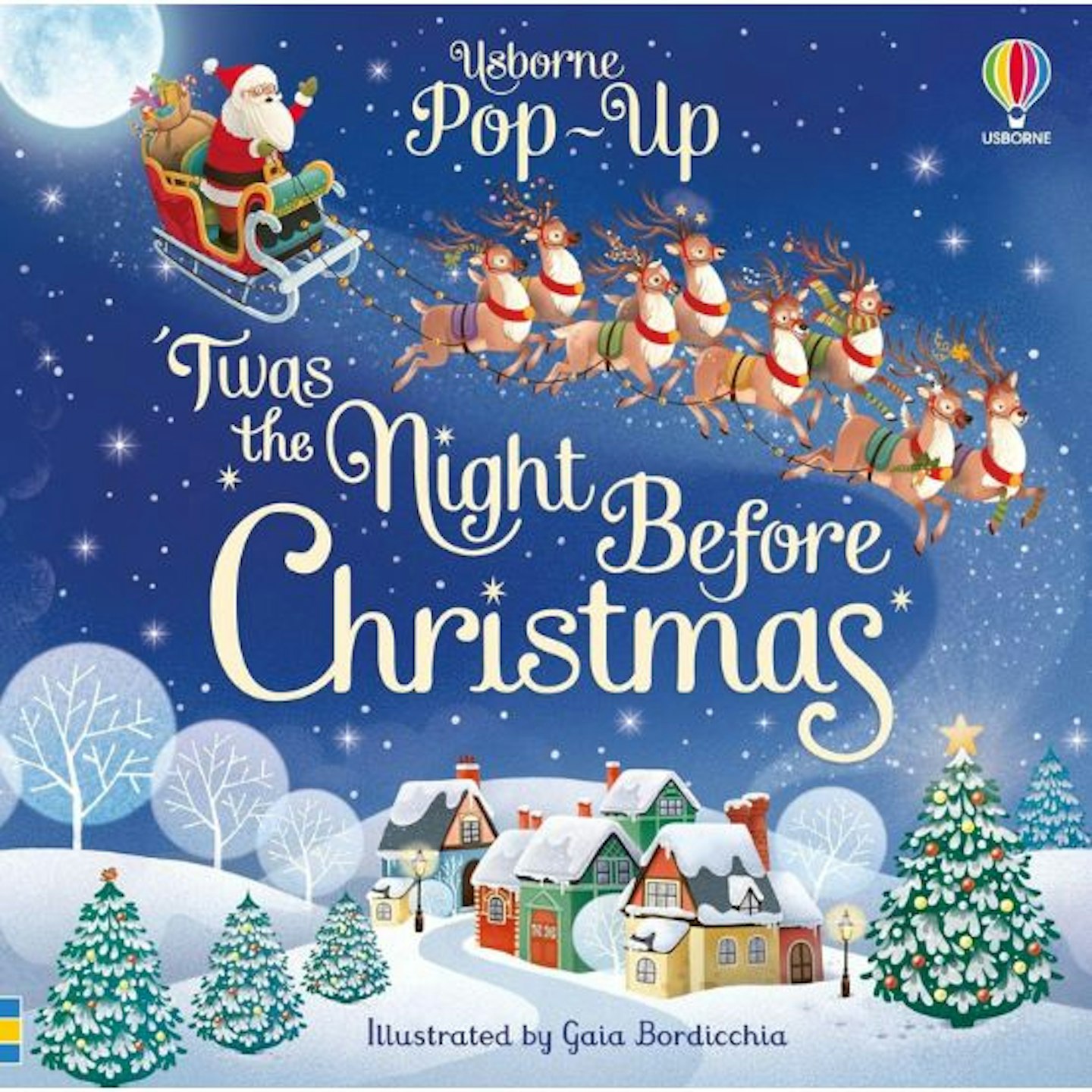 The cover of the Twas the night before Christmas showing a snowy scene with Father Christmas flying overhead with his reindeer