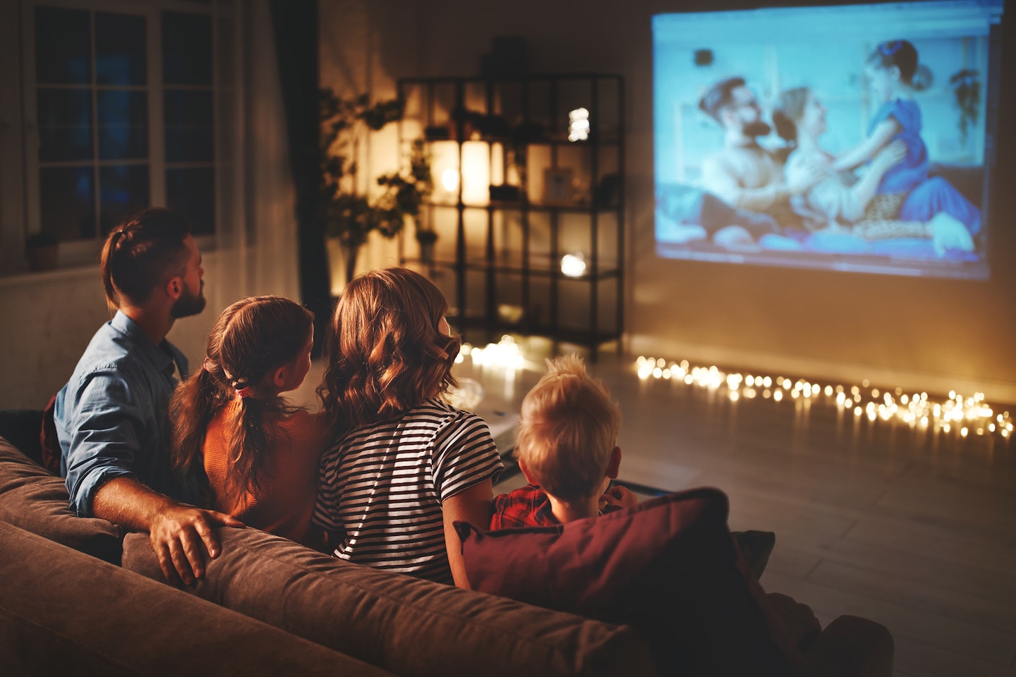 Family enjoying a movie night to spend quality time together.