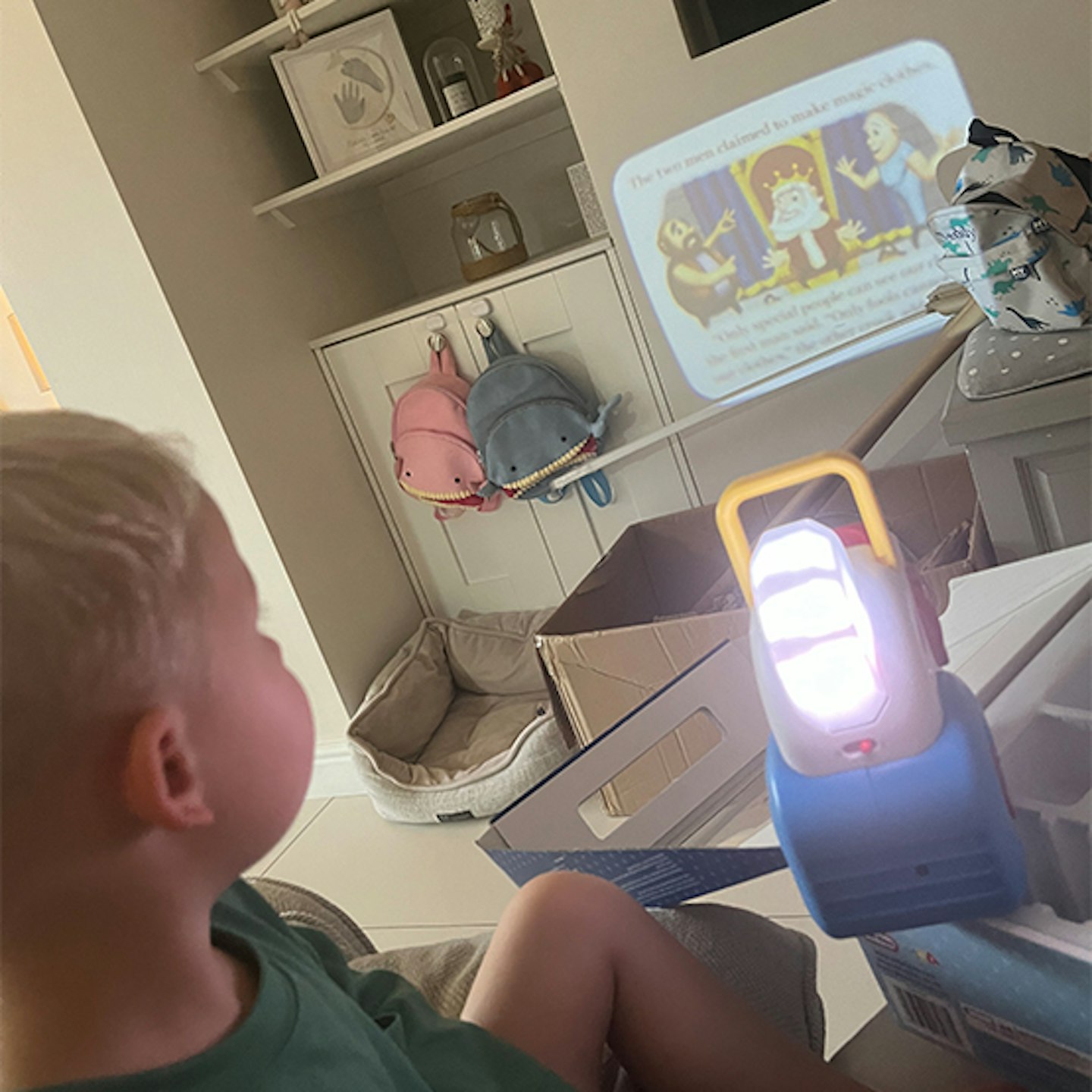 Little Tikes story dream projector onto a wall with a child watching