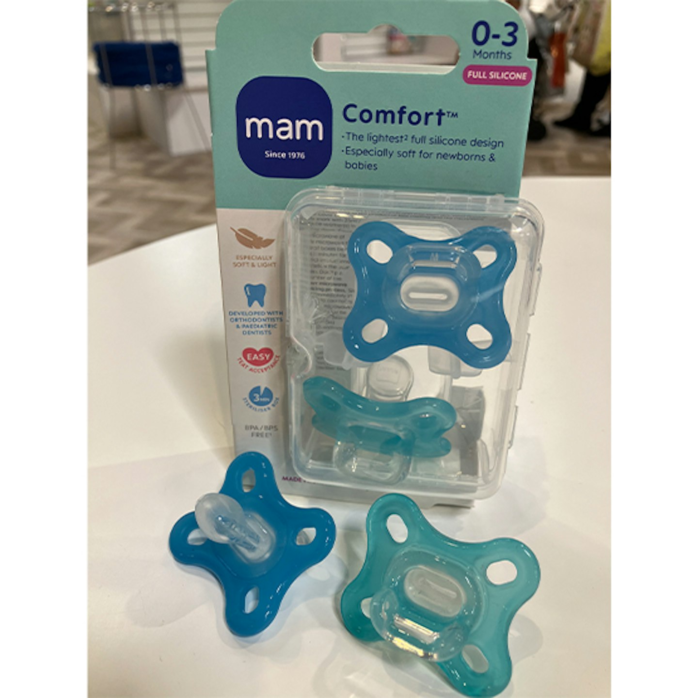 Two Blue MAM comfort soother on white table
