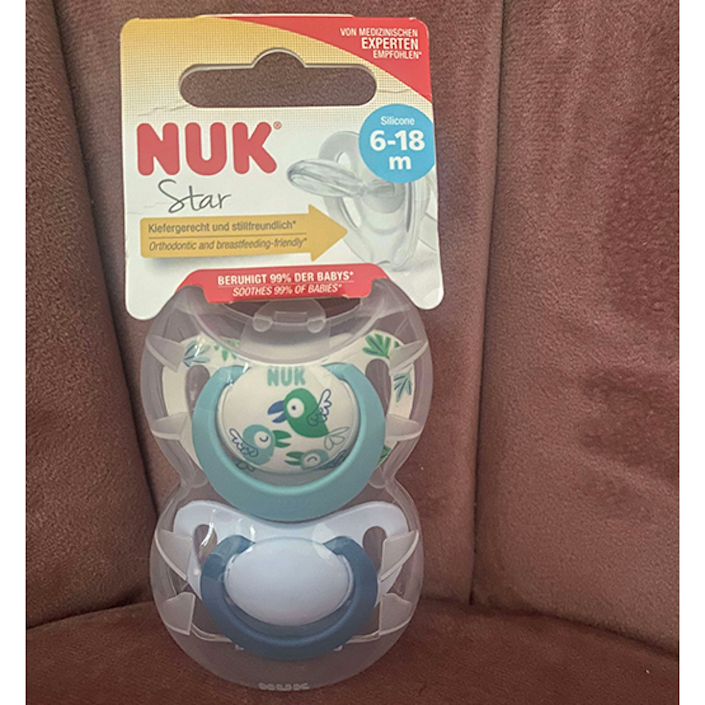 Nuk Star dummy in blue prints on pink chair