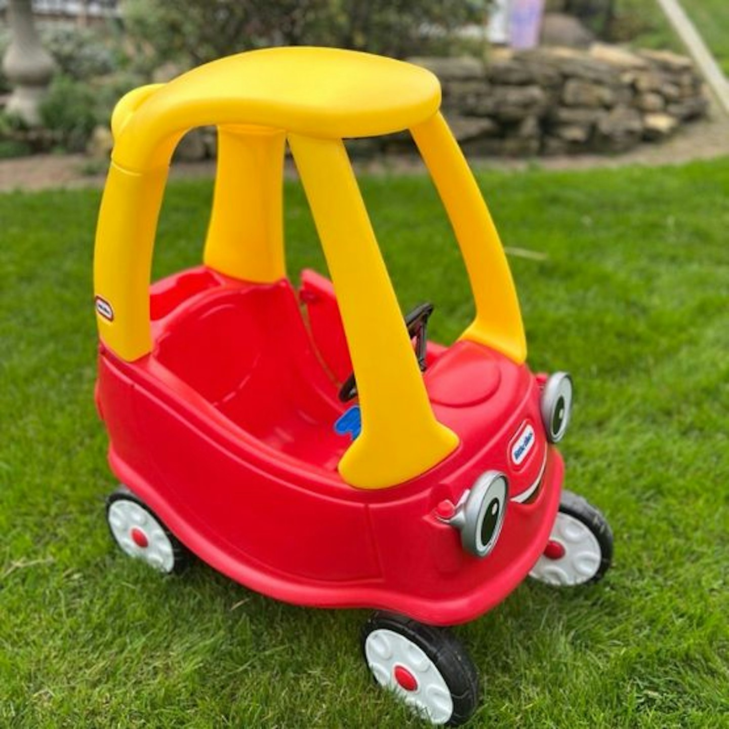 The Little Tikes Cozy Coupe on grass