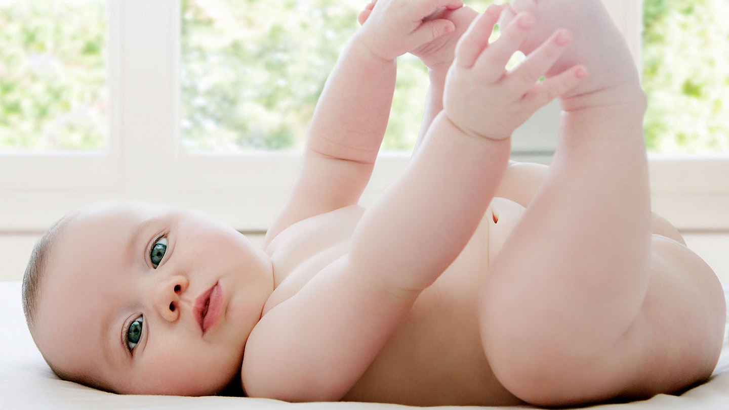 Baby laying on their back looking directly at the camera.