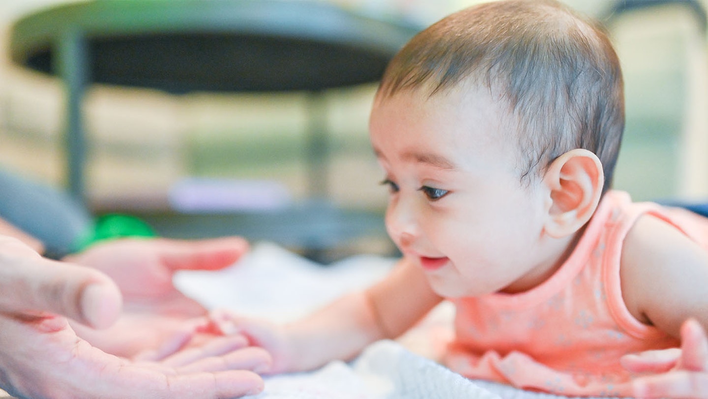 Baby holding their head up on their stomach gaing muscles that will help them walk.