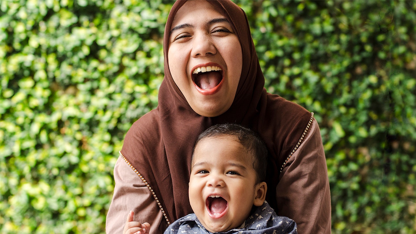 A mulism mother and her young son smiling and enjoying each others company.