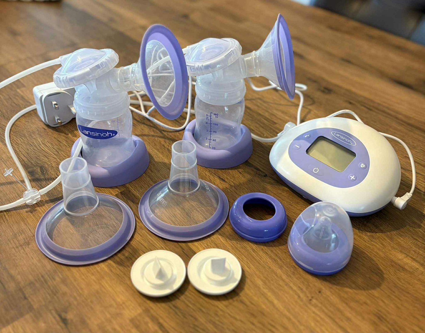 Lansinoh 2 in 1 Double Electric Breast Pump parts laid out on wooden table
