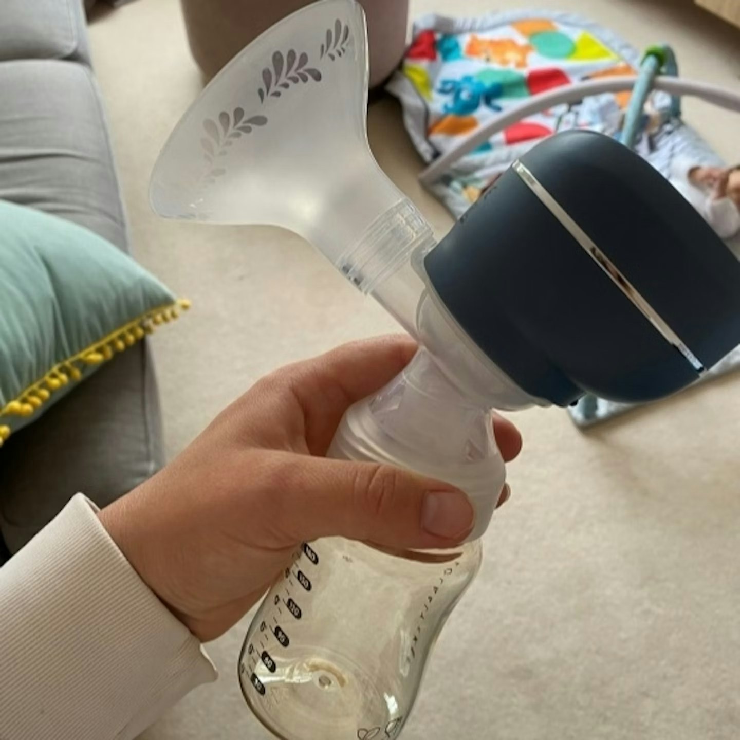 Image of a mum holding the lola and lykke electric breast pump in her house