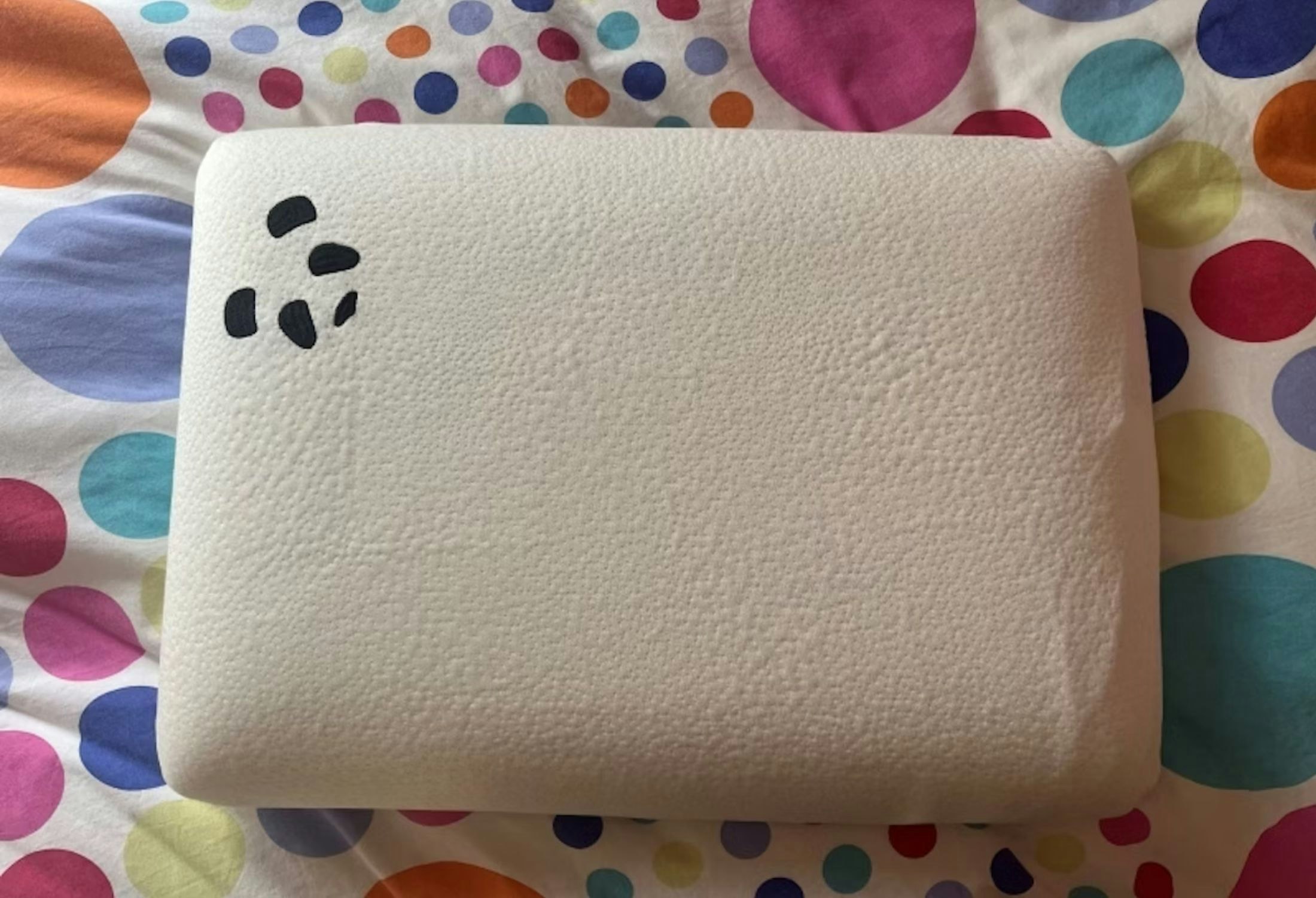 A Panda Kids Memory Foam Bamboo pillow on a colourful background