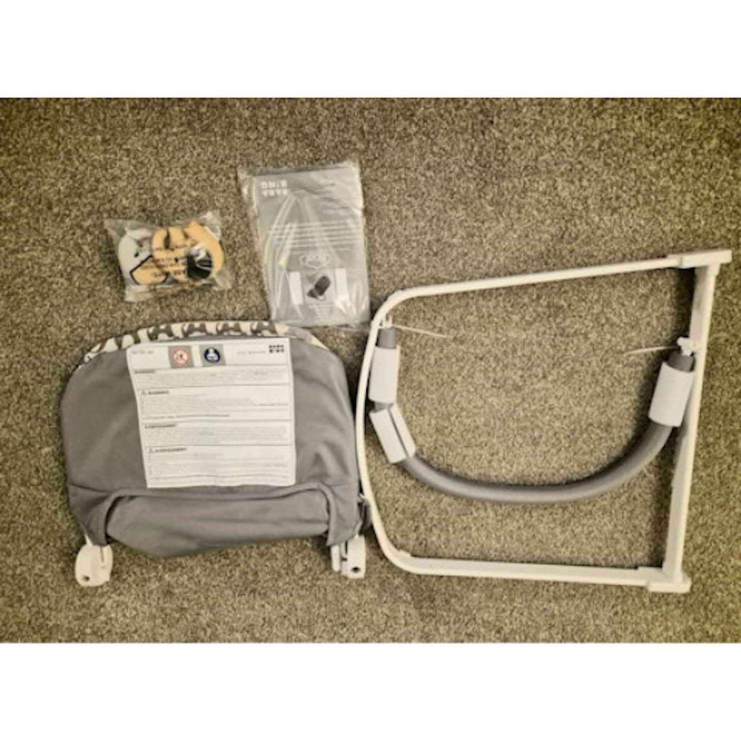 baby bouncer parts and accessories laid out on home carpet