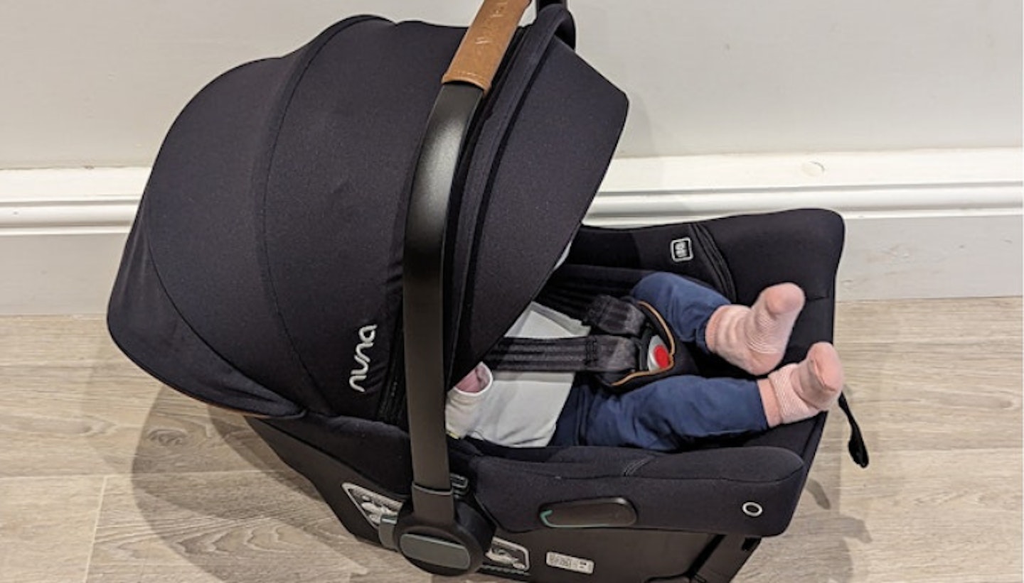 baby lying in Nuna car seat