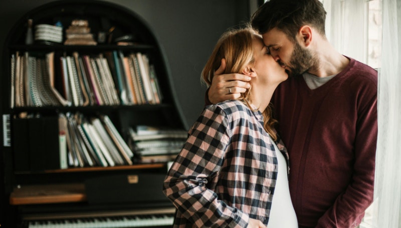 pregnant woman and partner kissing