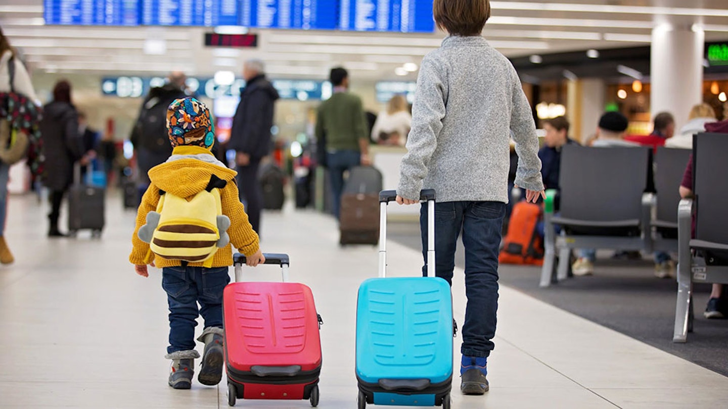 Toddler pulling a suitcase in an airport