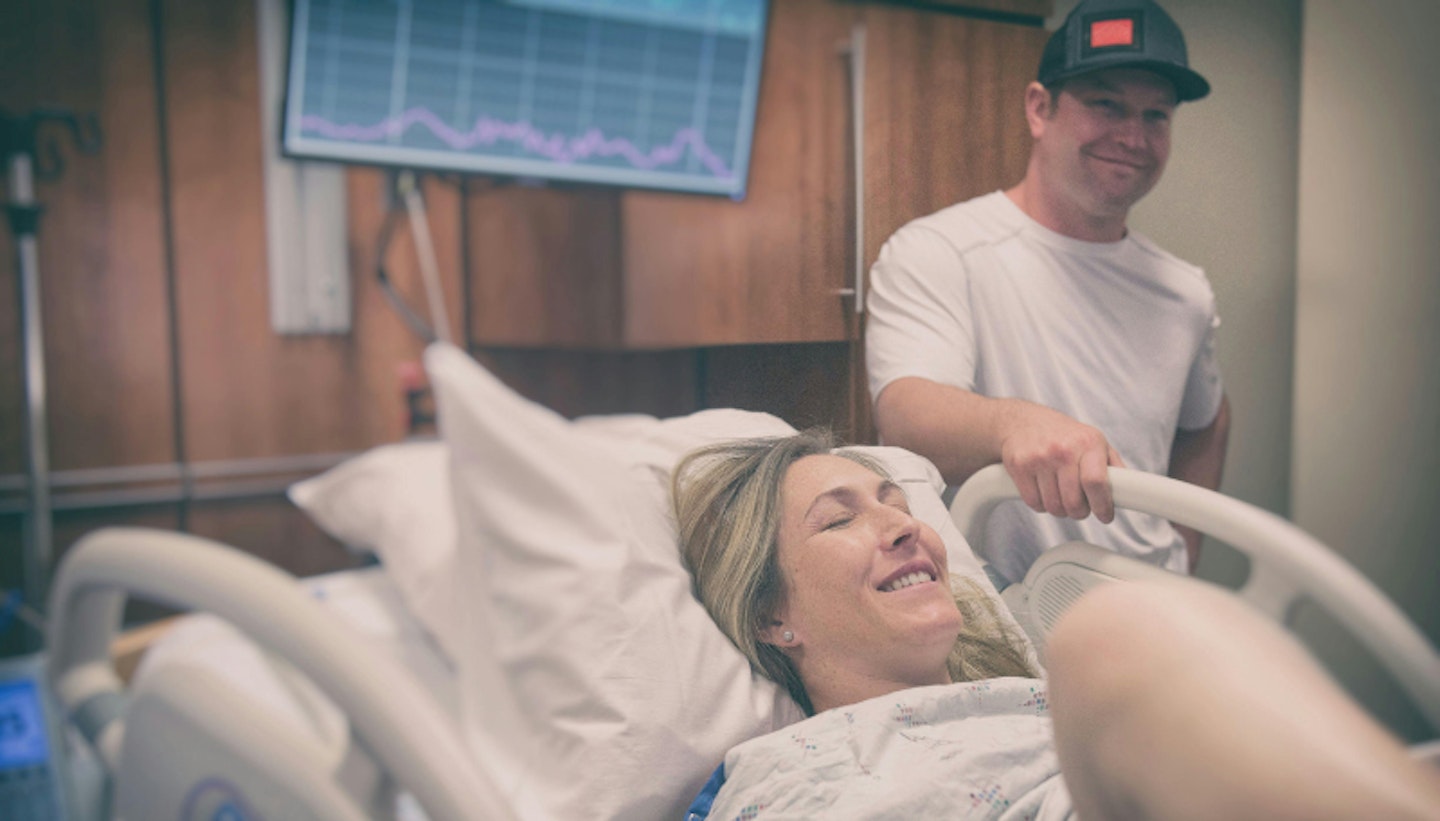 woman in labour with partner by the hospital bed