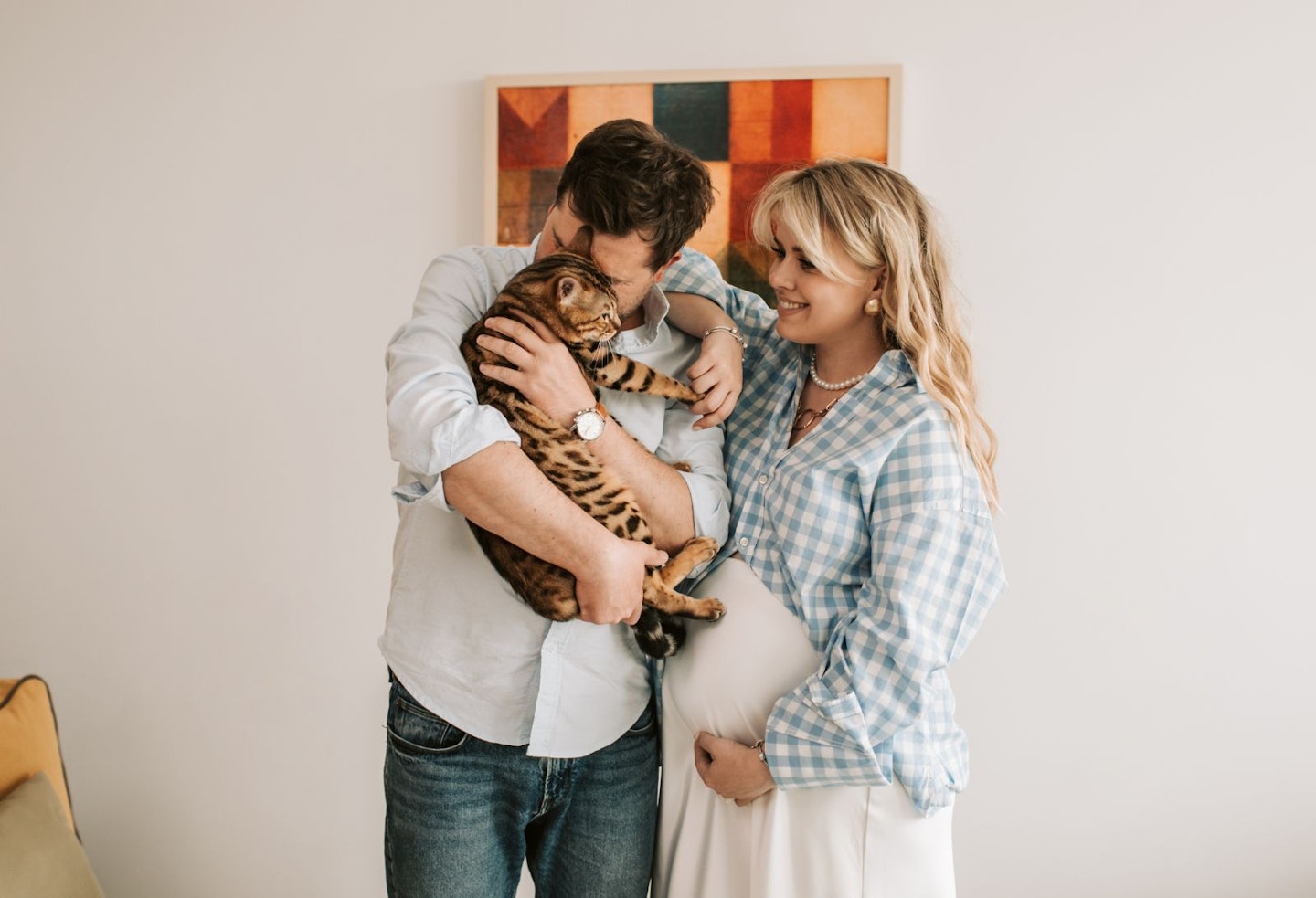 Pregnant Woman leaning on Man While carrying Pet Cat