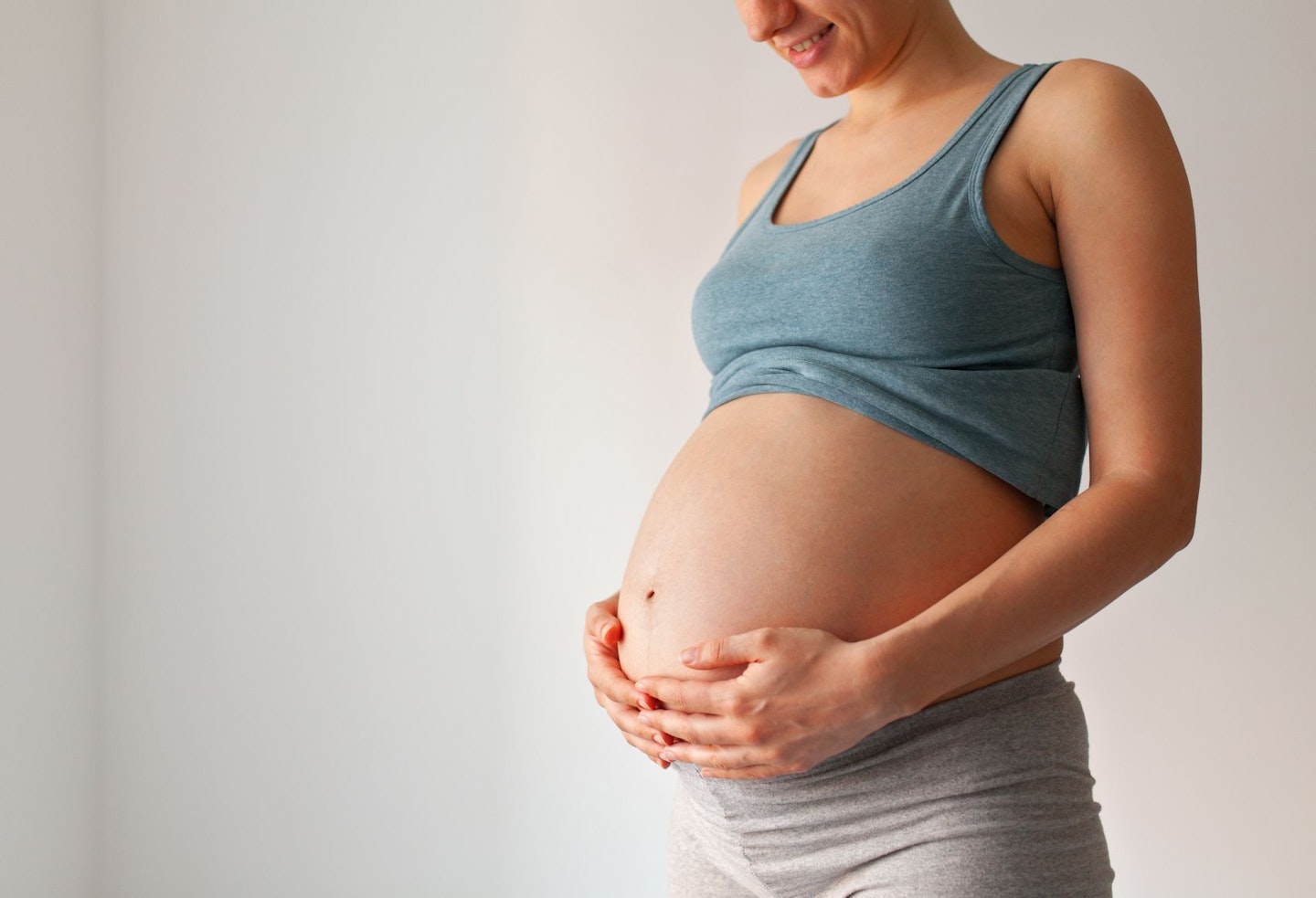 Pregnant woman standing against copyspace