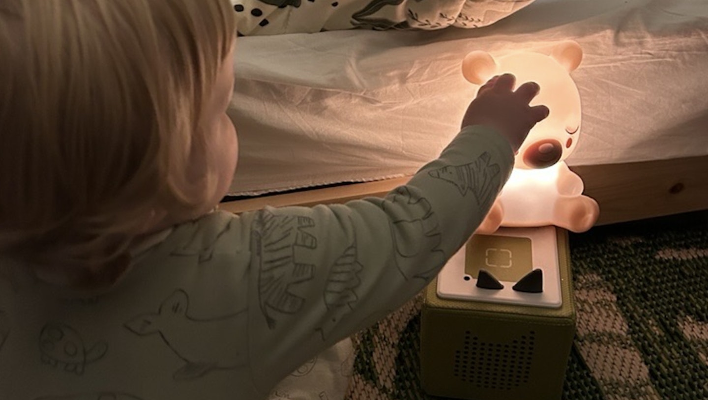 An image showing a baby touching a light up tonie box