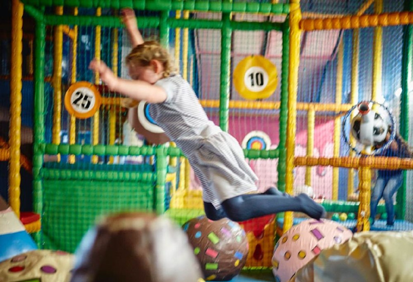 A girl jumping into the ball pit at Ice Cream Farm