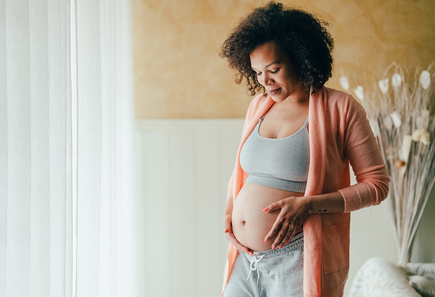 Pregnant woman looking at her bump