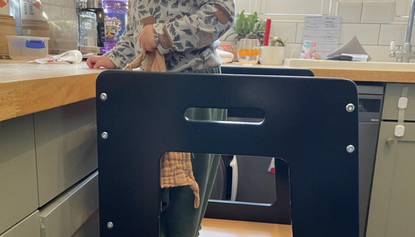 A collage of two images showing two different kids testing out the kiddymoon toddler learning tower in a kitchen with sage green kitchen cabinets