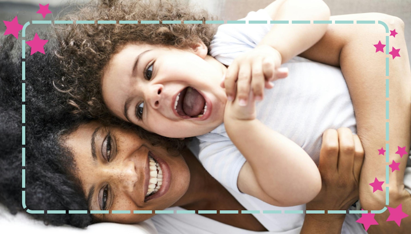 Curly afro-haired mum and child cuddling and laughing