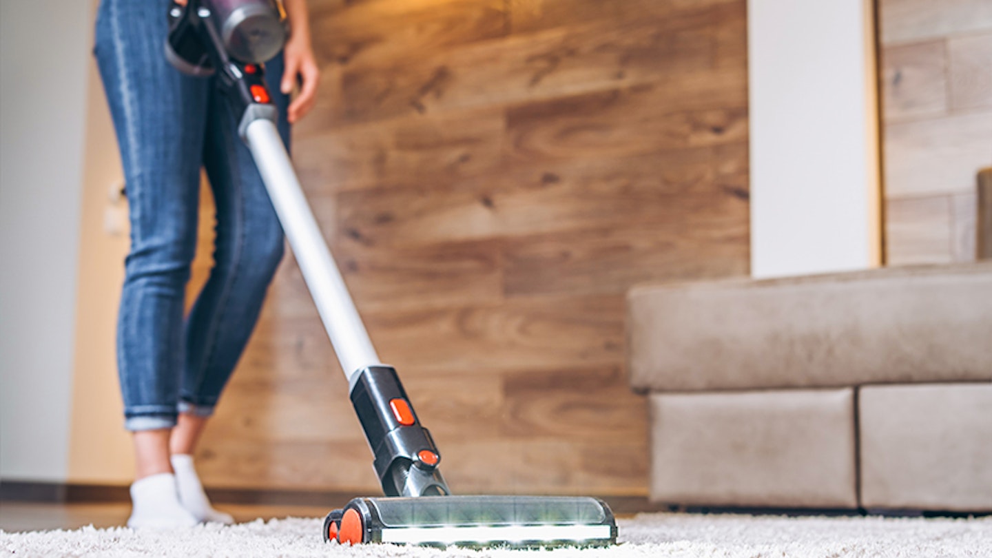 Woman cleaning carpet with cordless vacuum