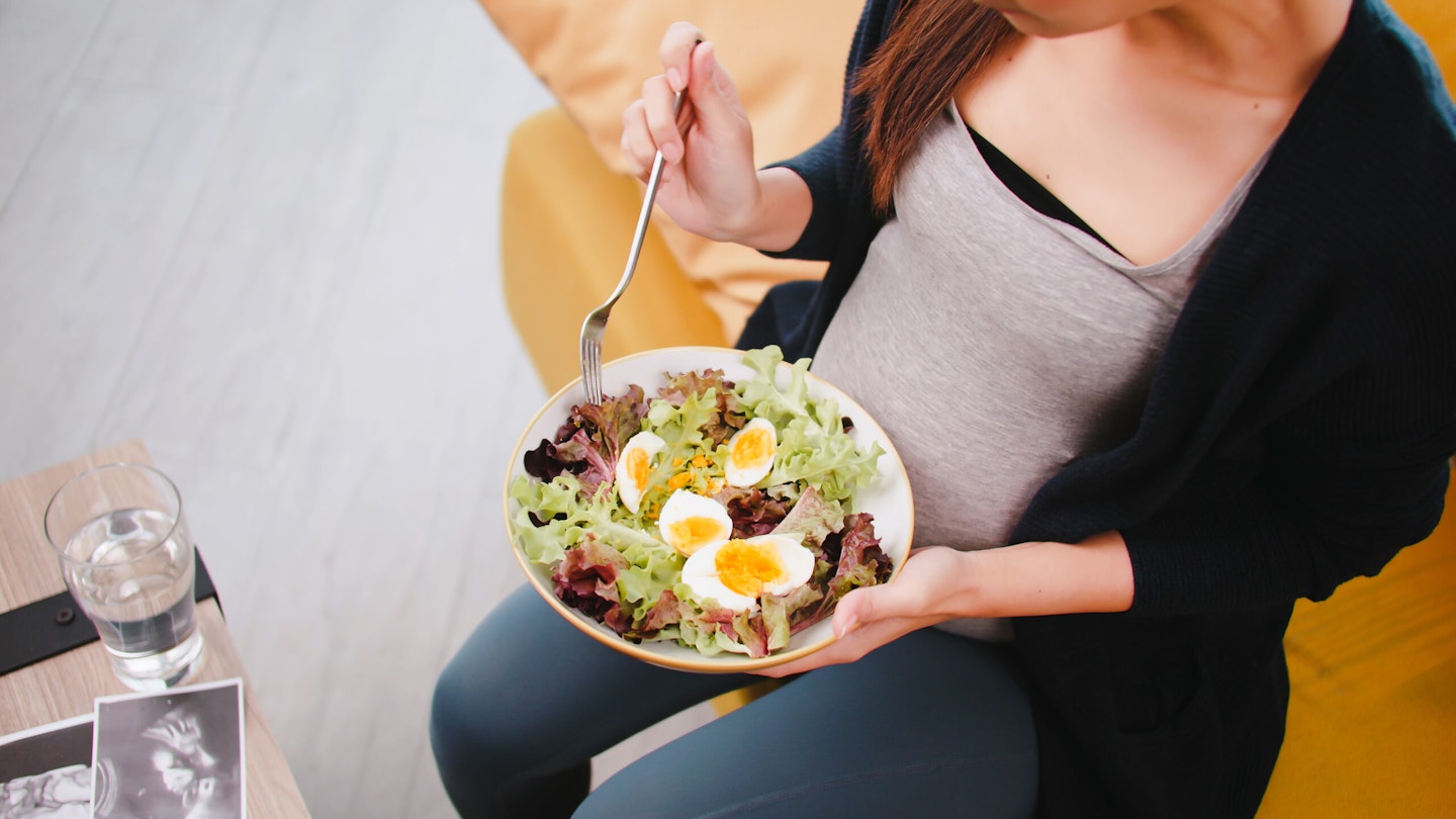 Pregnancy woman eating eggs and salad
