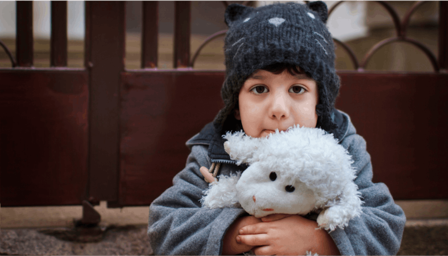 Child with sheep toy