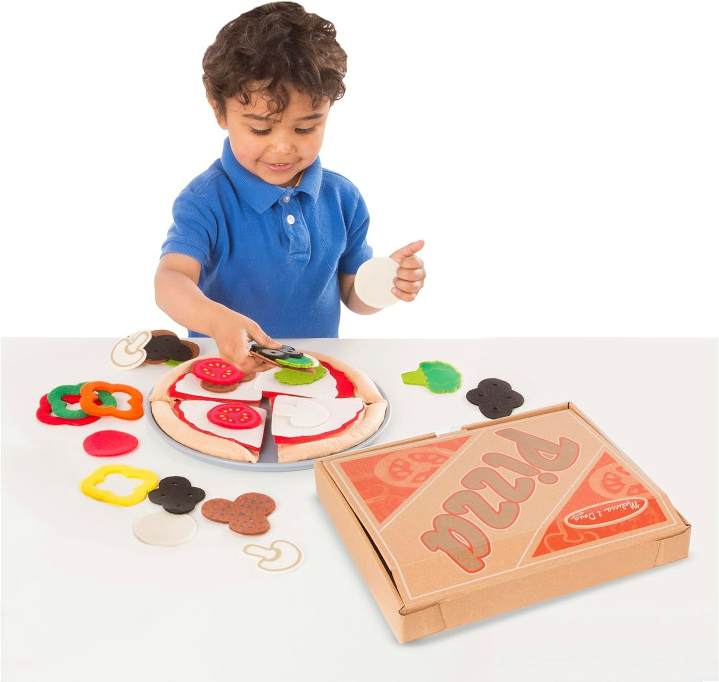 Boy putting felt toppings onto a felt toy food pizza base with realistic pizza box