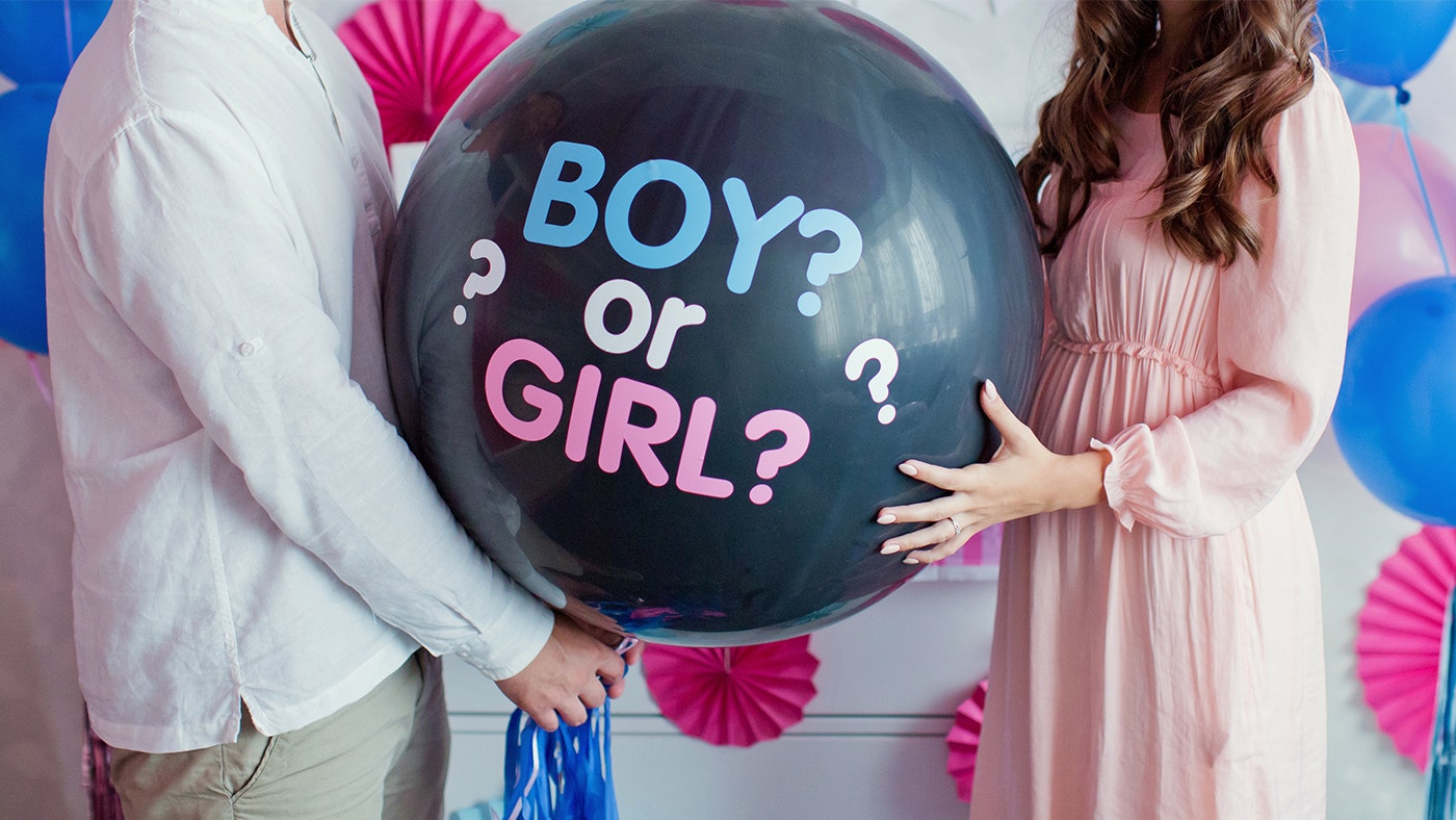 Man and woman holding black balloon with "boy or girl?" on gender reveal party