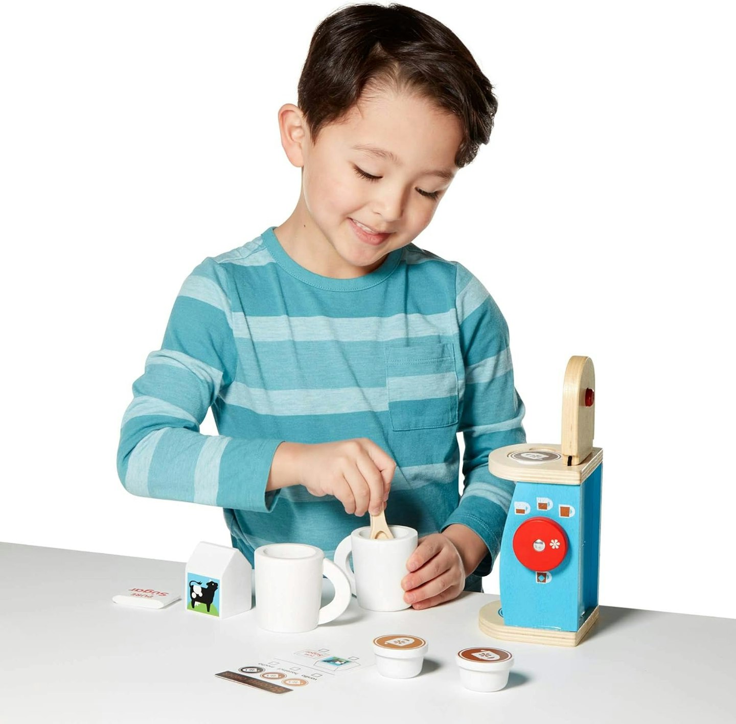 Boy playing at making pretend coffee with a wooden toy coffee machine and accessories