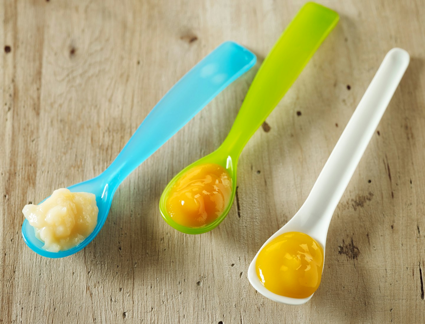 Baby spoons filled with baby food puree