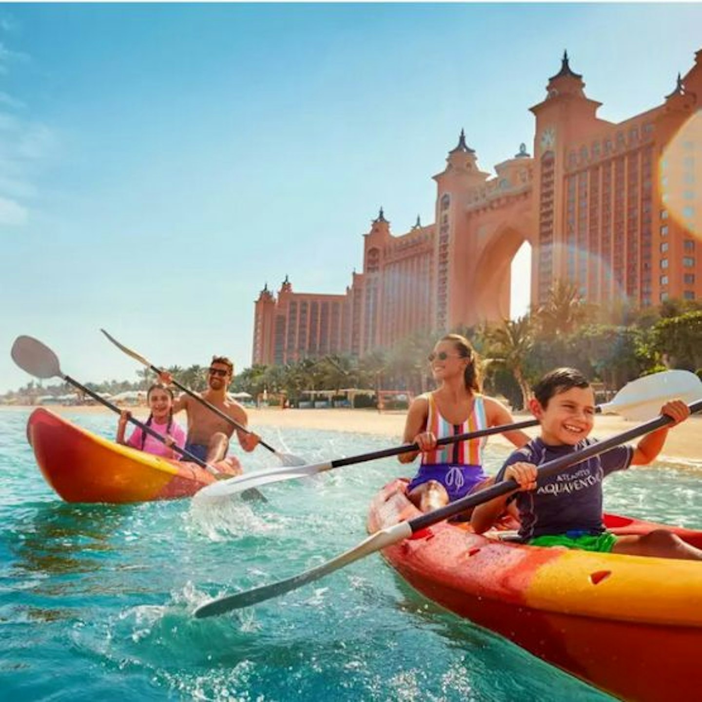 Family kayaking in front of Atlantis the Palm