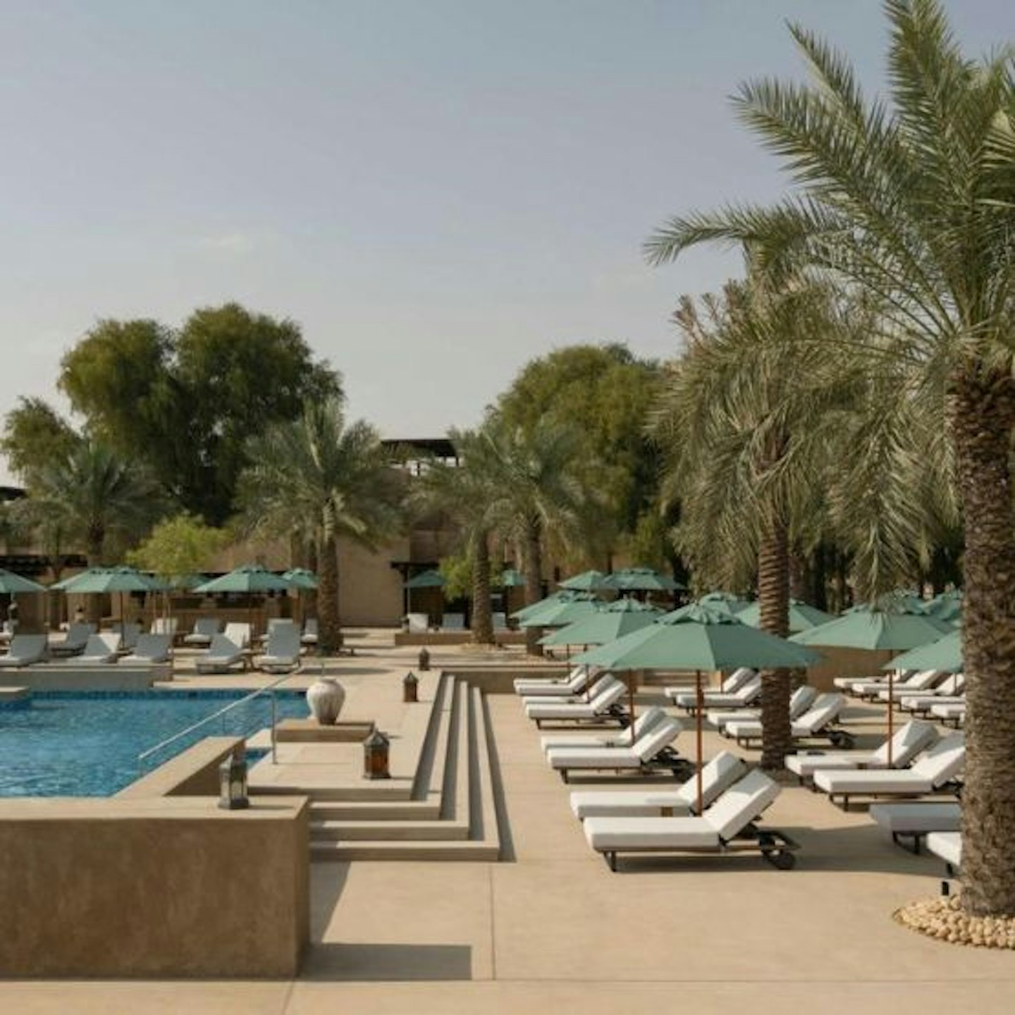 View of the pool, sun loungers and palm trees at Bab Al Sham, Dubai