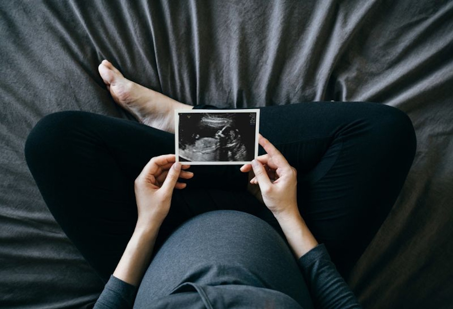Pregnant women holding a pregnancy scan photo