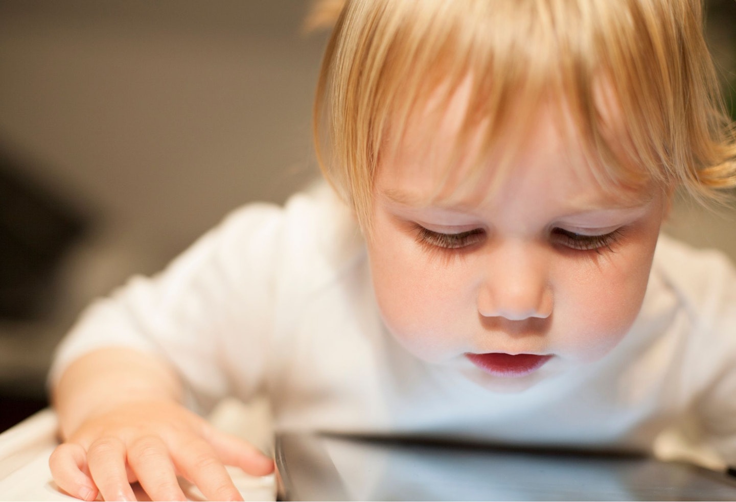 blonde baby looking at screen tablet