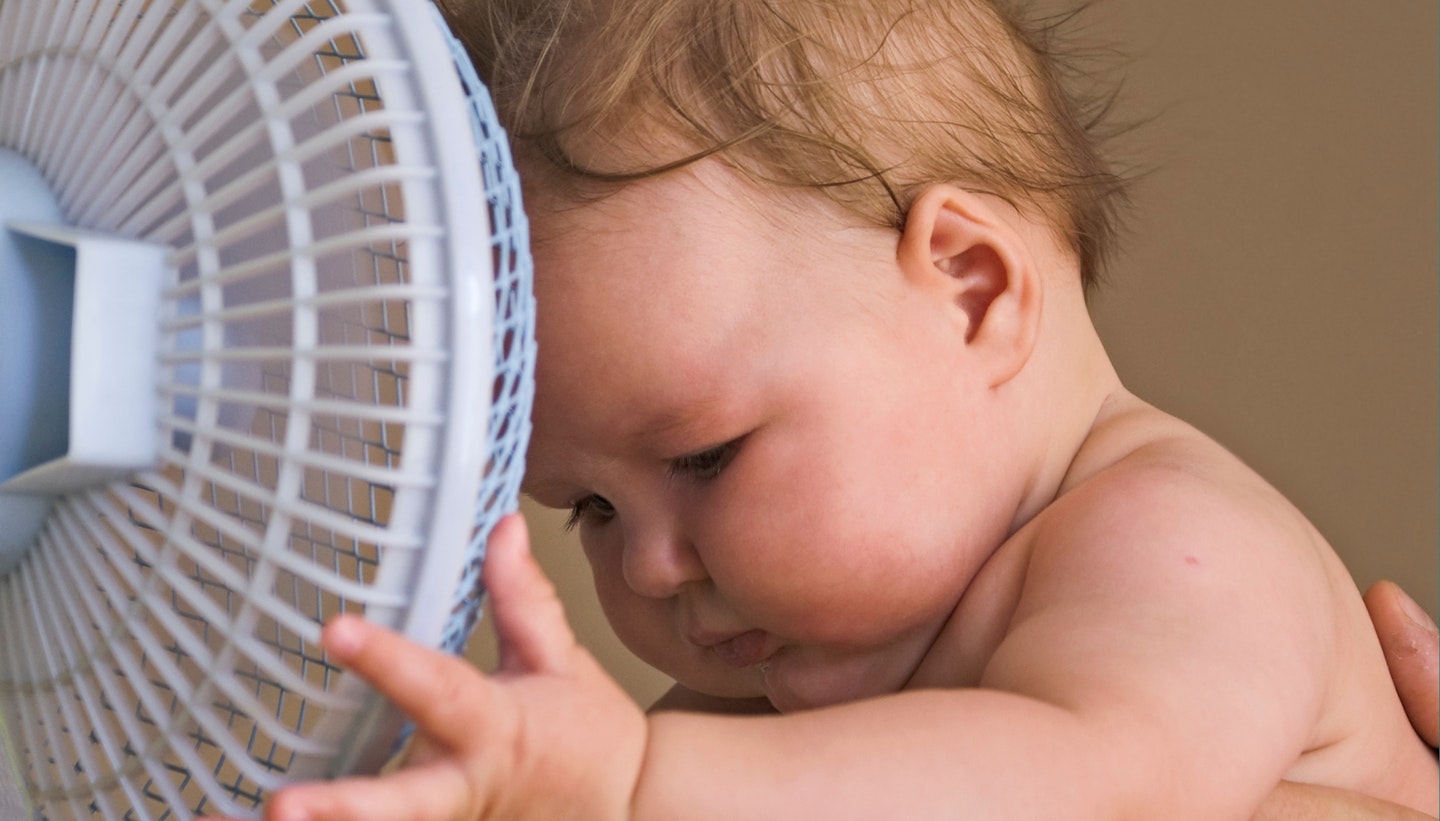 Sweaty baby holding a fan