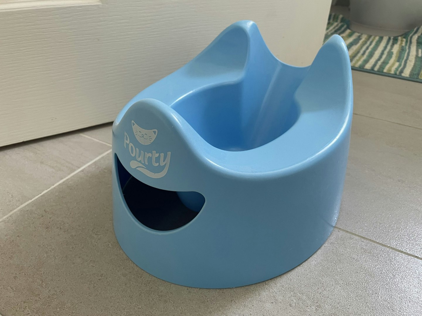 Pourty Easy-to-Pour Potty in blue placed on the floor