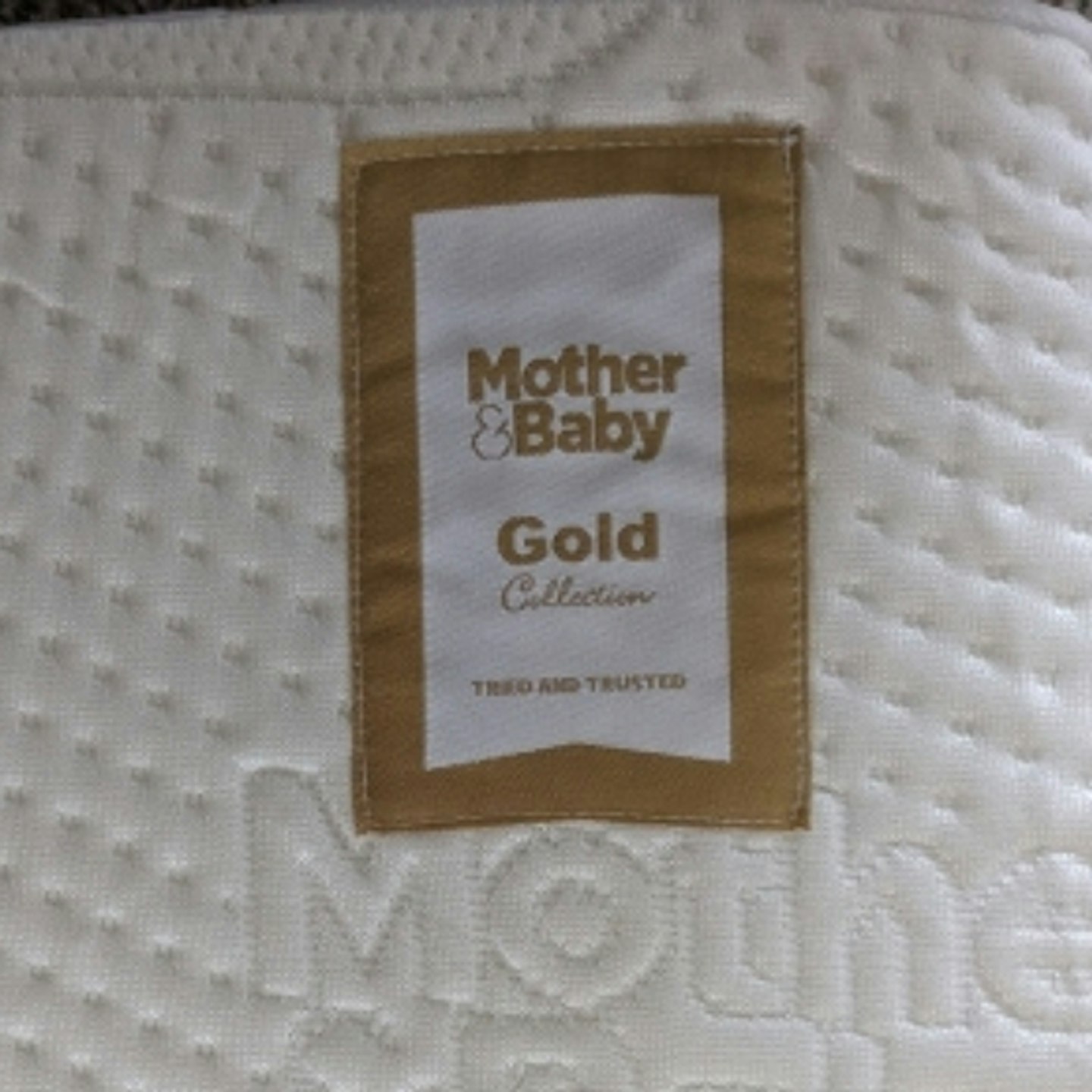 close up photo of the Mother+Baby Gold Award label stitched on to the Mother+Baby Pure Gold Anti-Allergy Coir Pocket Cot Bed Mattress