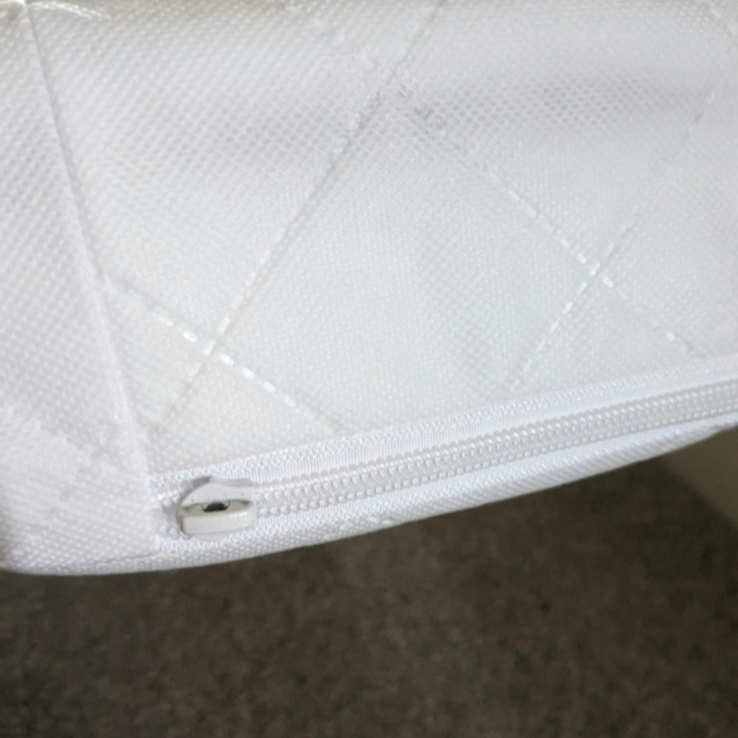 close up photo of the Mother+Baby Pure Gold Anti-Allergy Coir Pocket Cot Bed Mattress, showing the zipper