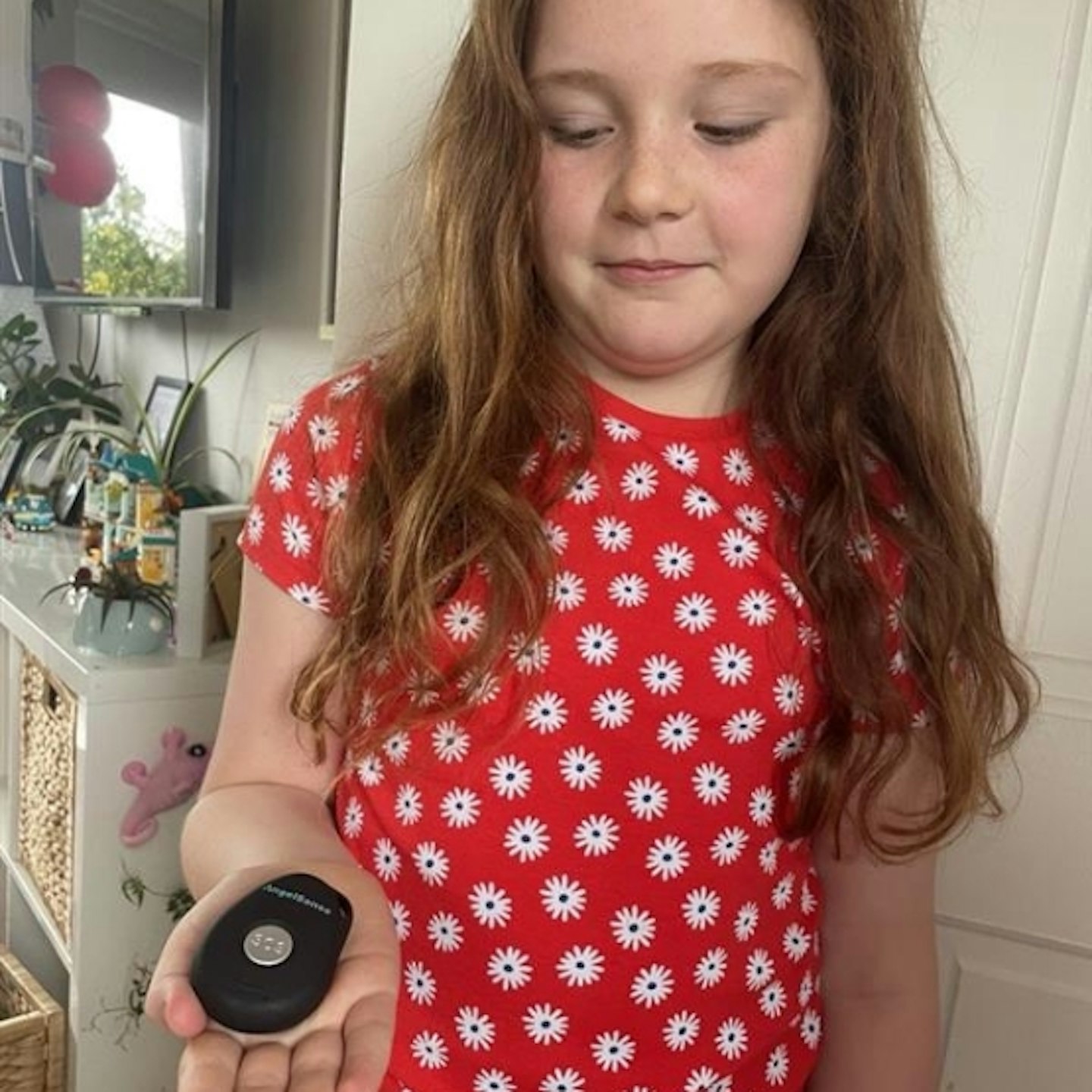 young girl holding AngelSense Personal GPS Tracker