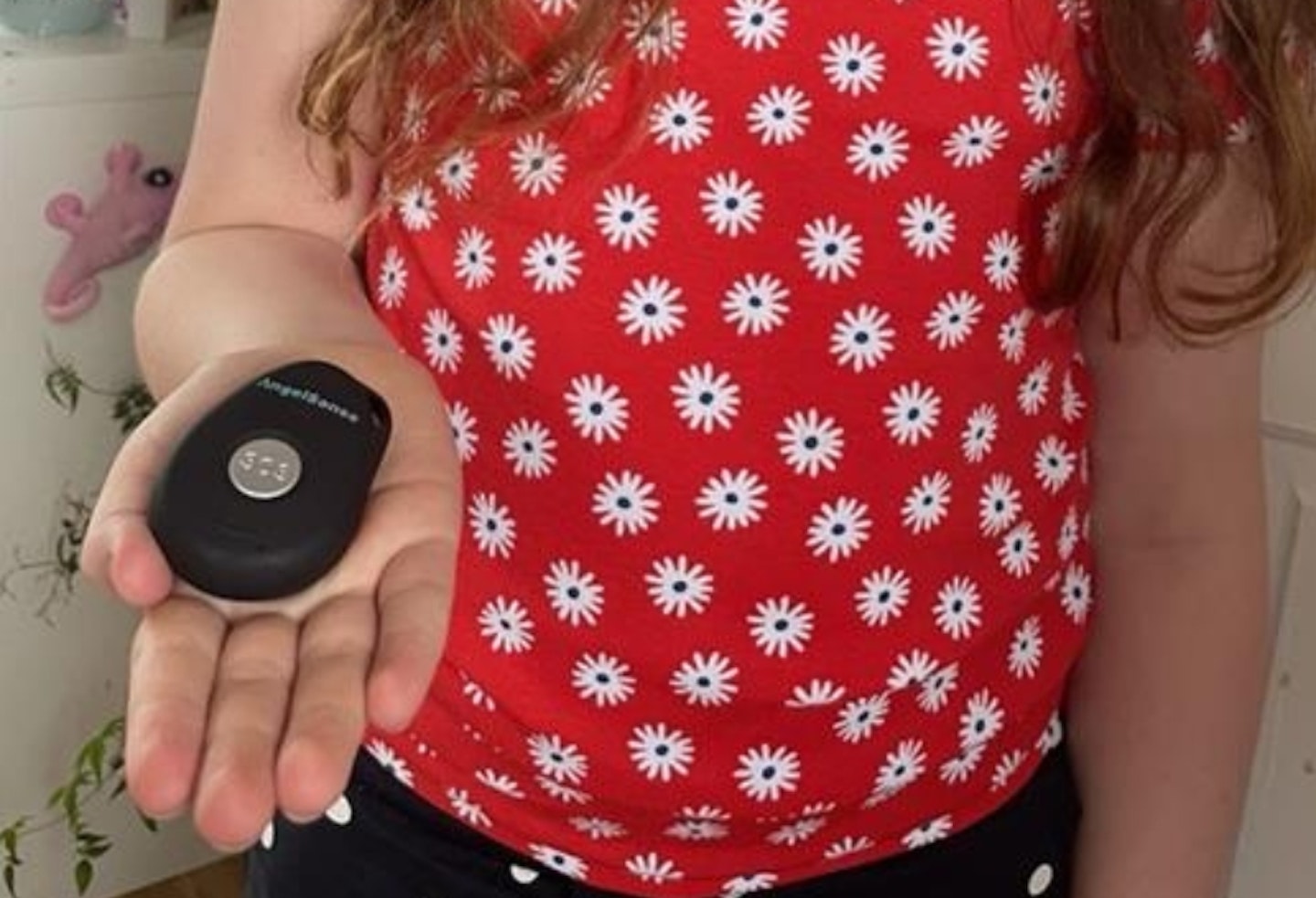 young girl holding AngelSense Personal GPS Tracker